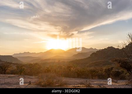 Golden sunset over mountain landscape with layered hills and dramatic sky in Mexico Stock Photo