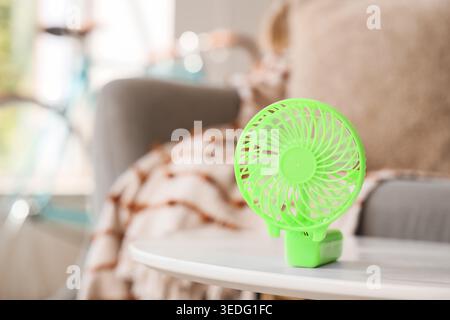 Green mini fan on table in living room, closeup Stock Photo
