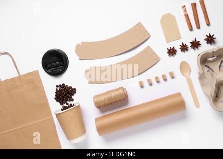 Composition with cup of coffee beans, spices and delivery paper bag on white background Stock Photo