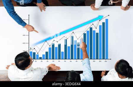 A group of professionals collaborates over financial charts, analyzing data trends and discussing strategic decisions for company growth and Stock Photo