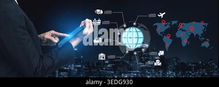 A business professional using a digital tablet to analyze global logistics and transportation networks in a modern city setting, showcasing innovation Stock Photo