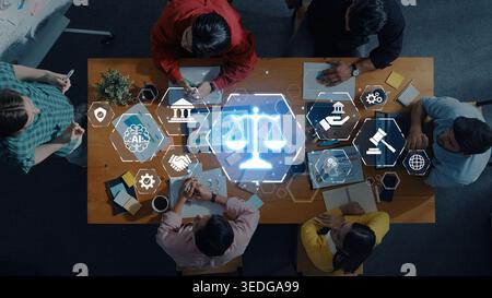 A diverse group of professionals collaborates in a modern workspace, utilizing digital tools and symbols of justice, law, and innovation for effective Stock Photo