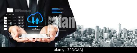 A businessman in a suit holds a tablet displaying a cloud data transfer graphic with a modern city skyline background, symbolizing technology and Stock Photo