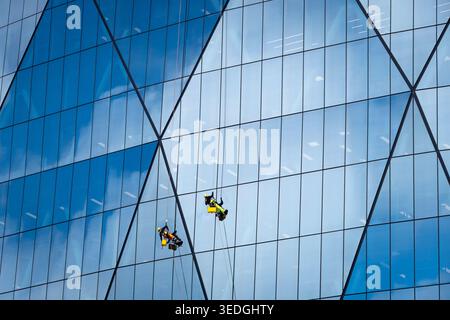 Window cleaners on glass tower building, Wellington, North Island, New Zealand Stock Photo