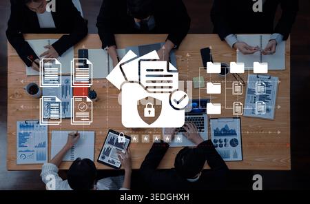 A business team is collaborating on data security strategies, showcasing various documents and digital devices, emphasizing the importance of Stock Photo