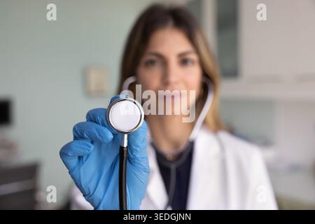 Cardiologist holds stethoscope toward camera, close up Stock Photo