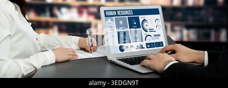 Human resources management software on computer screen helping human resources employee to manage recruitment, payroll, staff searching and KPI Stock Photo
