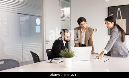 Focused professional team members analyzing business report during corporate meeting Stock Photo