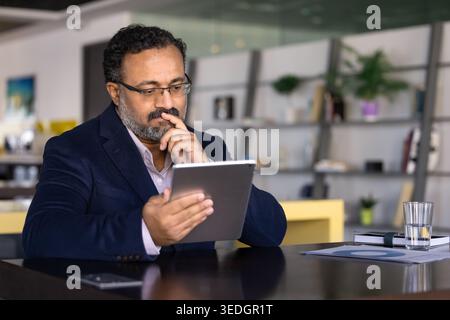 Professional man reviewing data on digital tablet Stock Photo