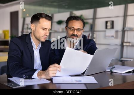 Two business men colleagues reviewing financial report Stock Photo