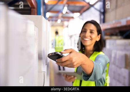 Closeup smiling female worker scanning barcode on box Stock Photo