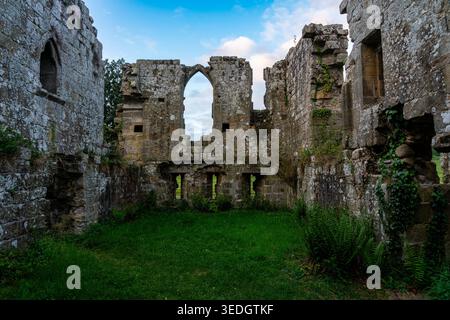 Roofless interior of Jervaulx Abbey with Gothic arched windows, ivy-clad walls and a grass floor open to the sky Stock Photo