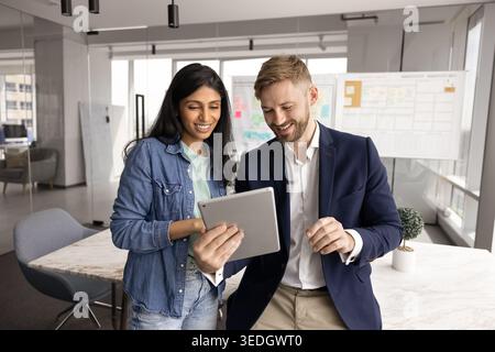 Two young 30s colleagues working on task using digital tablet Stock Photo