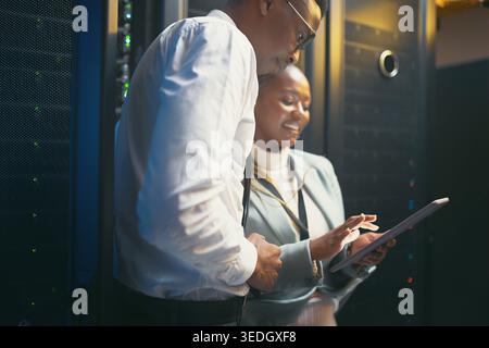 Smile, black people and programming with tablet in server room for research, coding and cybersecurity. Team, reading and digital for software update Stock Photo