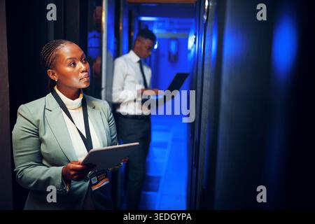 Thinking, programming and black woman in server room, tablet for software development or cyber security. People, programmer or solution in workplace Stock Photo