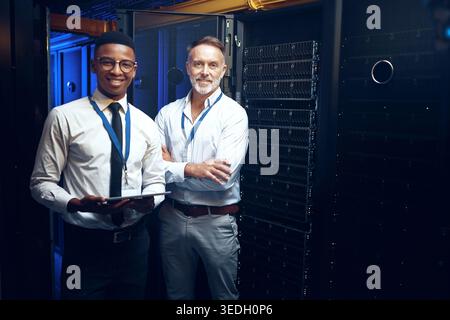 Men, portrait or team with tablet in server room for network security, storage or maintenance. Male people, IT technician or engineer with technology Stock Photo