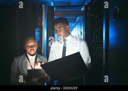 Black people, programming and tablet in server room at night for research, coding and cybersecurity. Team, overtime or technology for software update Stock Photo