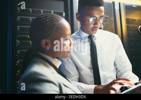 Black people, meeting and inspection with tablet in server room for research, coding and cybersecurity. Team, review and digital for software update Stock Photo