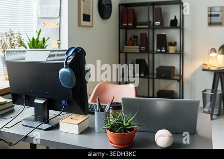 Home office workspace featuring desktop monitor, laptop, headphones, organizing tools for remote work and digital productivity. Ideal for hybrid work, freelance, startup marketing Stock Photo