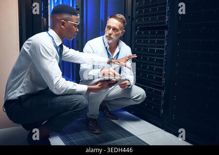 People, tablet or discussion in server room for problem solving, advice or security upgrade in business. Engineer, planning or tech in datacenter for Stock Photo