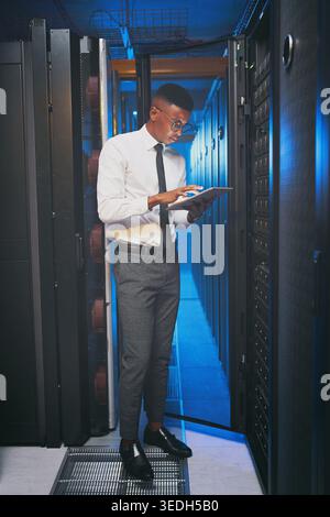 Tablet, technician or black man in server room for inspection, software update or machine learning. Cyber security, tech or person in data center for Stock Photo