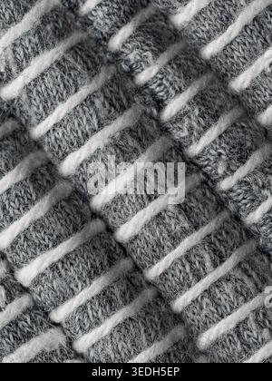 Macro texture of grey and white knitted wool fabric with diagonal ribs Stock Photo
