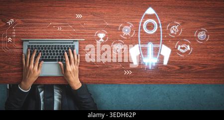 Hands Typing on Laptop with Creative Rocket Launch Concept for Innovation and Business Growth on Wooden Desk Sigmoid Stock Photo