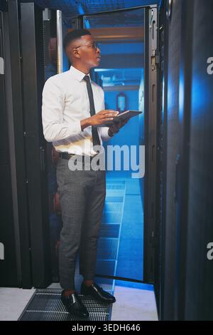 Tablet, technician or black man in data center for inspection, software update or machine learning. Cyber security, tech or person in server room for Stock Photo
