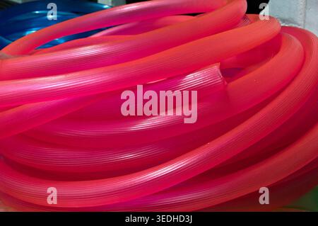 many long pink red plastic pipe for building Stock Photo