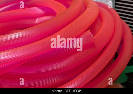many long pink red plastic pipe for building Stock Photo