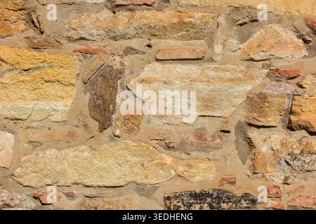 Ancient composite stone wall with bricks as background Stock Photo