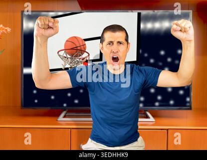 Pointer! Man watching basketball match on television at home and celebrating the triumph Stock Photo
