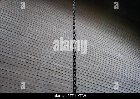 Hanging Chain against a Minimal Brick Wall Background Stock Photo