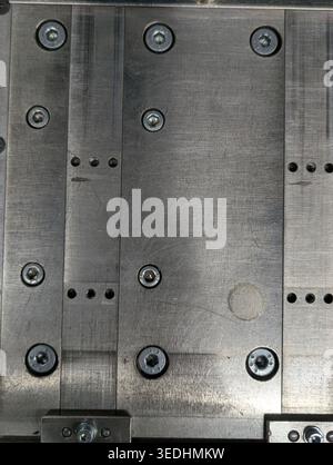Brushed Steel Panel With Exposed Fasteners, Rivets And Screws Arranged In Grid, Machined Surface Showing Grinding Marks, Subtle Oil Stains And Welded Stock Photo