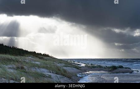 Sunbeams breaking through storm clouds over Baltic Sea beach in Mazirbe, Latvia Stock Photo
