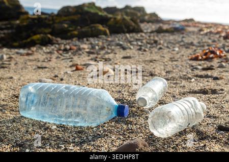 Plastic water bottles waste on the sandy beach Stock Photo