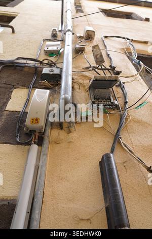 Complex electrical wiring and utility boxes on a city wall in Clermont-Ferrand, France Stock Photo