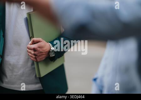 Business people meeting outdoors holding documents and exchanging a casual greeting Stock Photo