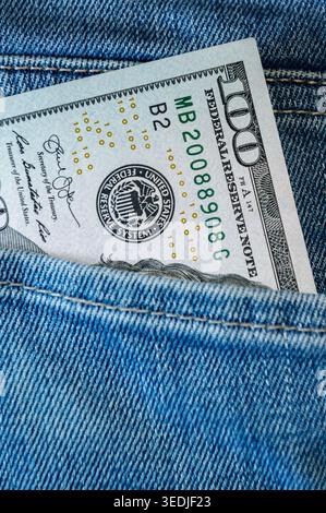 Close-up of a stack of one hundred US dollar banknotes in the back pocket of blue jeans. Concept of personal finance, hidden cash, savings, income, or Stock Photo