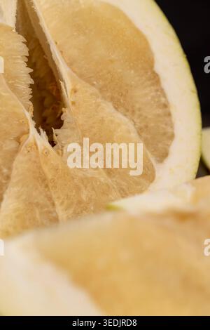Citrus on a wooden surface, cut sweet citrus with large slices against the background of old boards with an authentic look and natural light up close. Stock Photo