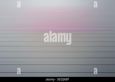 Abstract background featuring soft pink light fading into a gray gradient with subtle horizontal lines and a grainy texture. Stock Photo