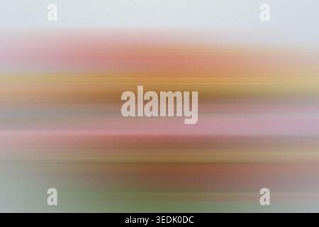 An abstract background featuring horizontal motion blur with soft gradients of pink, orange, and yellow, creating a serene and dreamlike atmosphere. Stock Photo