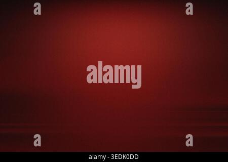A deep, dark red background featuring a soft gradient and a fine, subtle grain texture, creating a moody and atmospheric aesthetic. Stock Photo