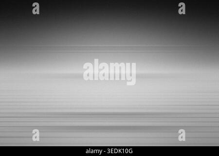 An abstract background featuring subtle horizontal lines and a grainy, textured surface in shades of grey and white, creating a minimalist aesthetic. Stock Photo