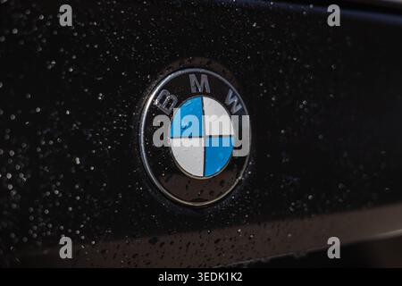 Slovenia, Ljubljana - 8 April 2026: BMW logo displayed on a dark surface with water drops present. Stock Photo
