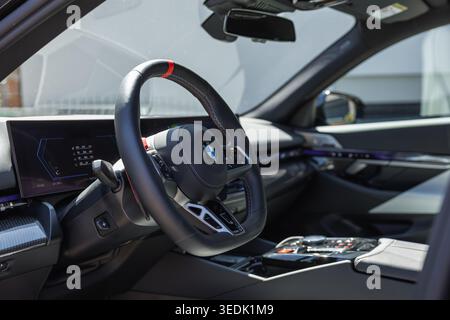Slovenia, Ljubljana - 8 April 2026: Inside the BMW M5, the steering wheel and dashboard highlight advanced elements. Stock Photo