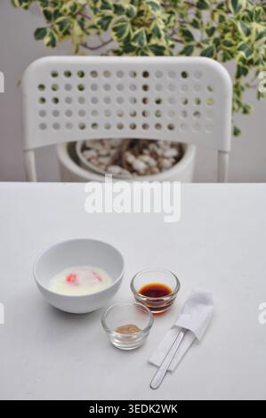 soft boiled egg or half boiled egg served with soy sauce and white pepper served in a white bowl on white table, kopitiam style Stock Photo