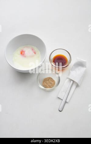 soft boiled egg or half boiled egg served with soy sauce and white pepper served in a white bowl on white table, kopitiam style Stock Photo