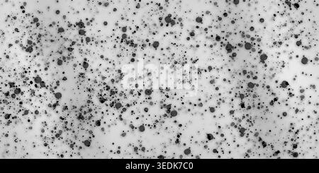 A high-resolution abstract background featuring scattered black ink splatters and droplets of various sizes on a clean white surface. Stock Photo