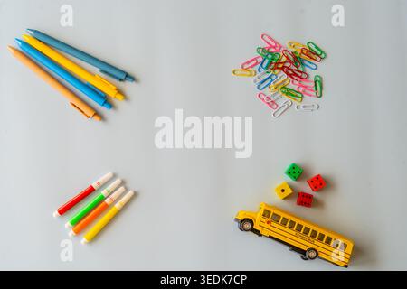 Studygram flatlay with dopamine desk supplies, colorful pens clips markers and toy school bus on clean surface, analog productivity mood, schoolcore Stock Photo